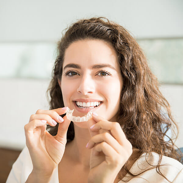 A woman holding her Invisalign® aligners
