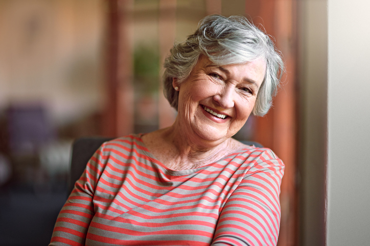 Senior woman in striped shirt smiling brightly